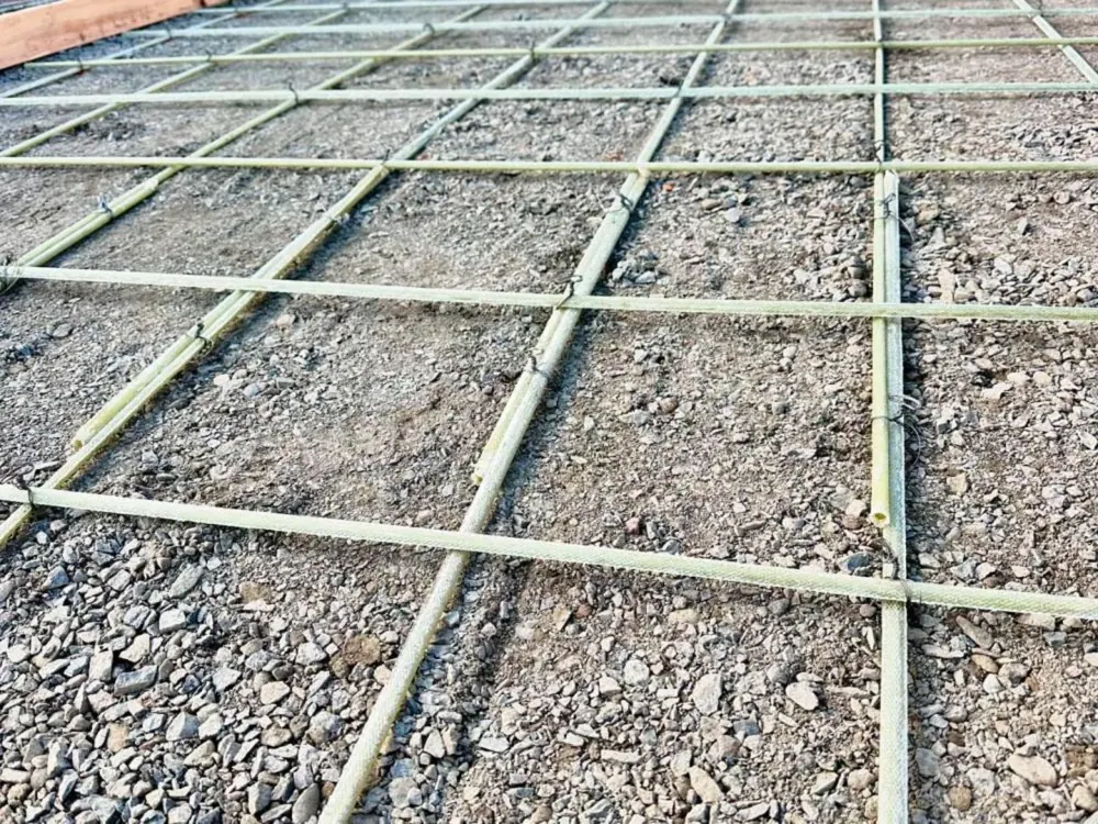 Close-up of reinforcement grid on a compacted aggregate base before concrete placement
